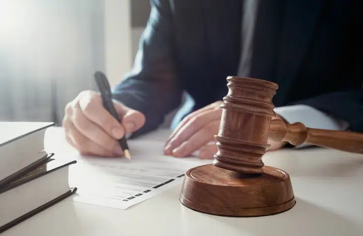 Trustee signing documents beside a gavel
